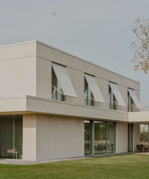 GAISS rests house's linear symmetrical volume on timber-clad plinth in latvia