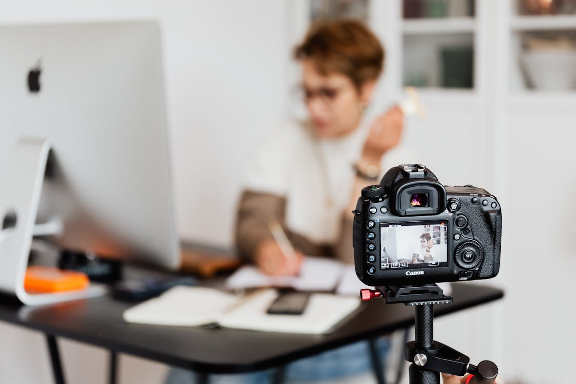 Professional photo camera taking photos of anonymous businesswoman