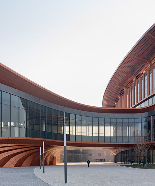 zaha hadid's beijing convention center shaped as series of copper-colored 'ribbons'